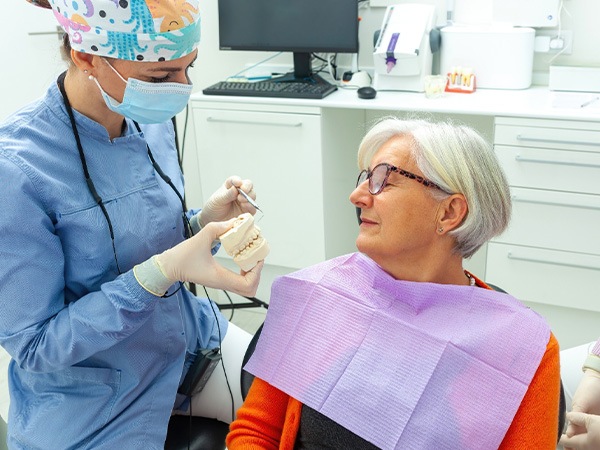 A dentist discussing the possibility of dental implants with a patient during a consultation