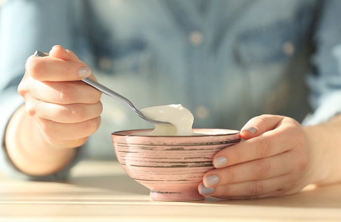 Person eating a bowl of yogurt