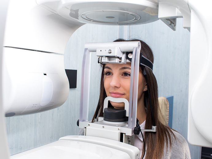 Dental patient receiving a C T cone beam scan of her mouth and jaws