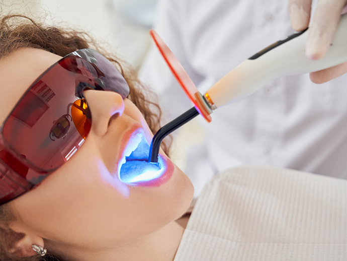 Woman having her teeth scanned by her dentist