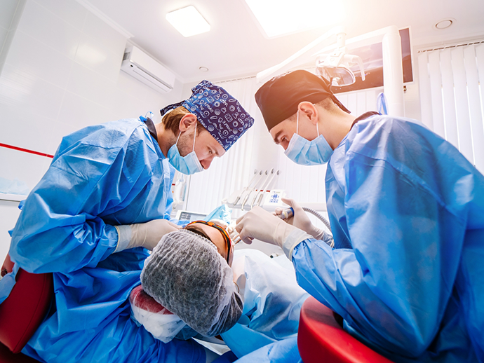 Dentist and assistant performing a dental procedure on a patient