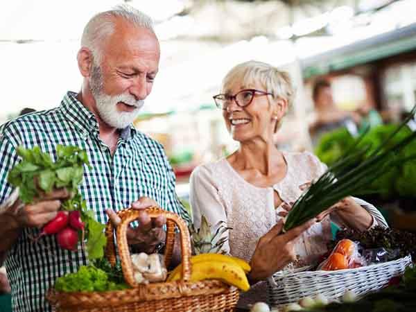 An older couple buying healthy foods to eat