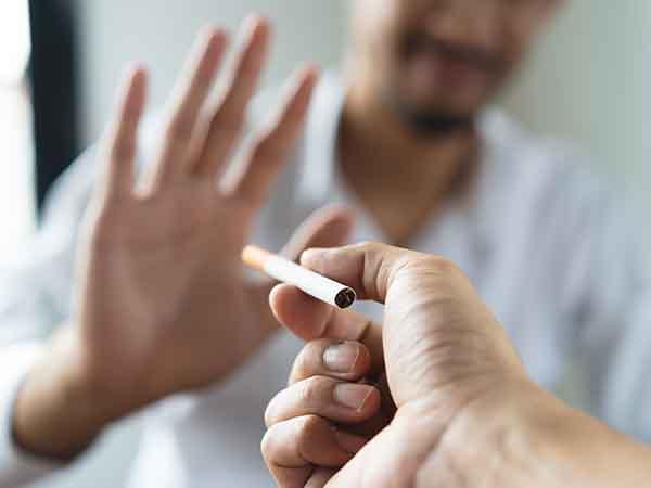 A closeup of a hand rejecting a cigarette